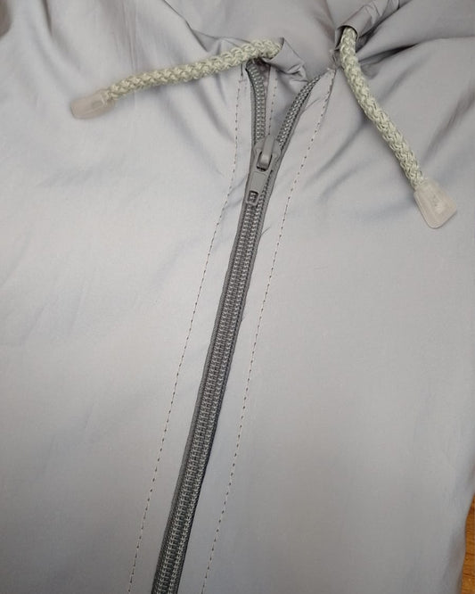 Chaqueta reflectiva con cierre gris perla.